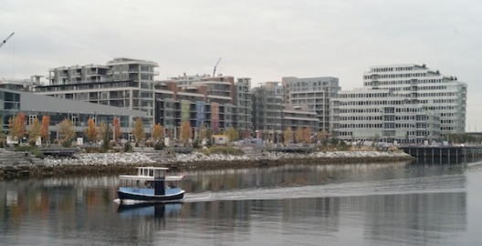 A water taxi plies its trade in False Creek as the nearly completed Athletes' Village for the 2010 Olympic Winter Games sits along the shore in Vancouver