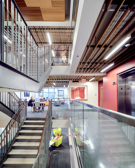 Livability is enhanced by a combination of daylighting, finely tuned acoustics, and clear sight lines in the open-stair hall. Image courtesy Prakash Patel.