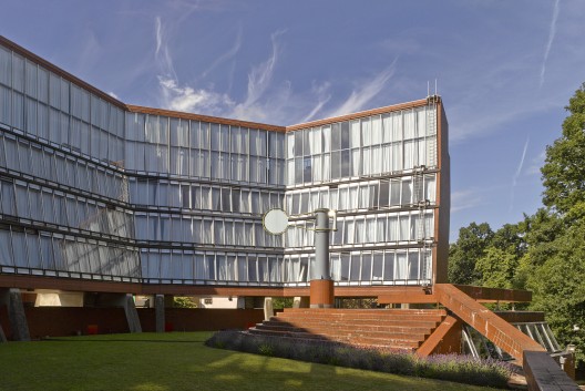 View showing the raised glass facade wrapping the social courtyard / © James Brittain