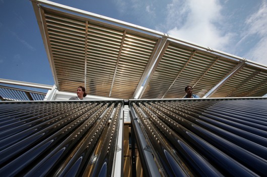 Brianna Bacon, right, and Lizzie DeLeonibus, left, of Maryland look out over Florida International University's solar thermal collector system at West Potomac Park in Washington, D.C., Wed., Sept. 28, 2011. Image © Stefano Paltera/U.S. Department of Energy Solar Decathlon