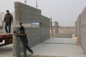 Workmen assembling one of Winsun's printed walls. Image courtesy of Wall Street Journal
