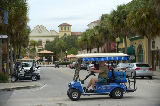 Residents drive golf carts through the main square of the Spanish Springs neighborhood of The Villages, Florida. Image © Phelan M. Ebenhack/AP Photo