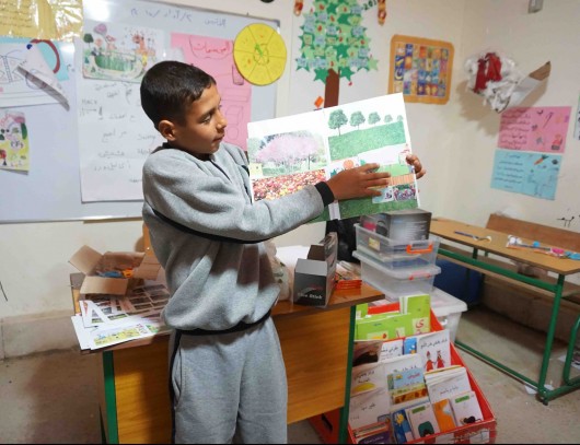 A child poses with his plan for a safe playground. Image © CatalyticAction